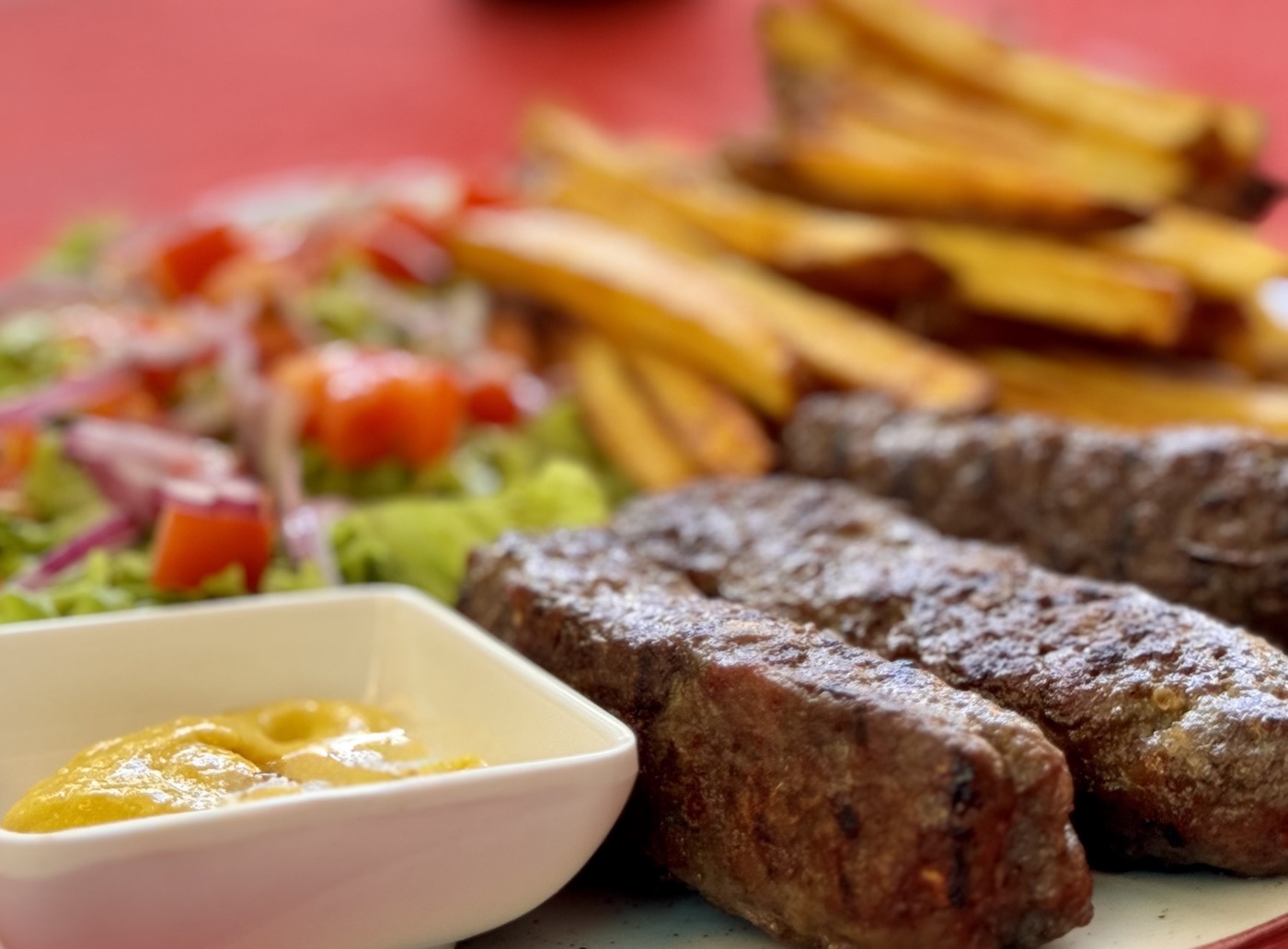 Mici romenos na grelha com mostarda — churrasco de verão típico da Romênia
